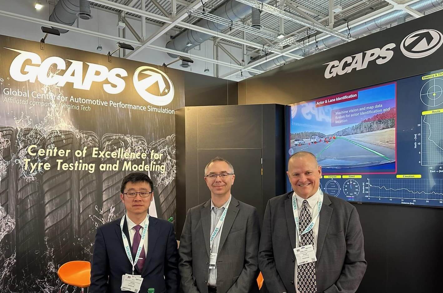 Dr. Yi Li, Modeling and Simulation Engineer, Jon Darab, Director of Operations, and Evan Lowe, Director of Business Development stand in front of the GCAPS booth at TTX.